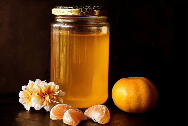 Medus stiklainyje ir mandarinas